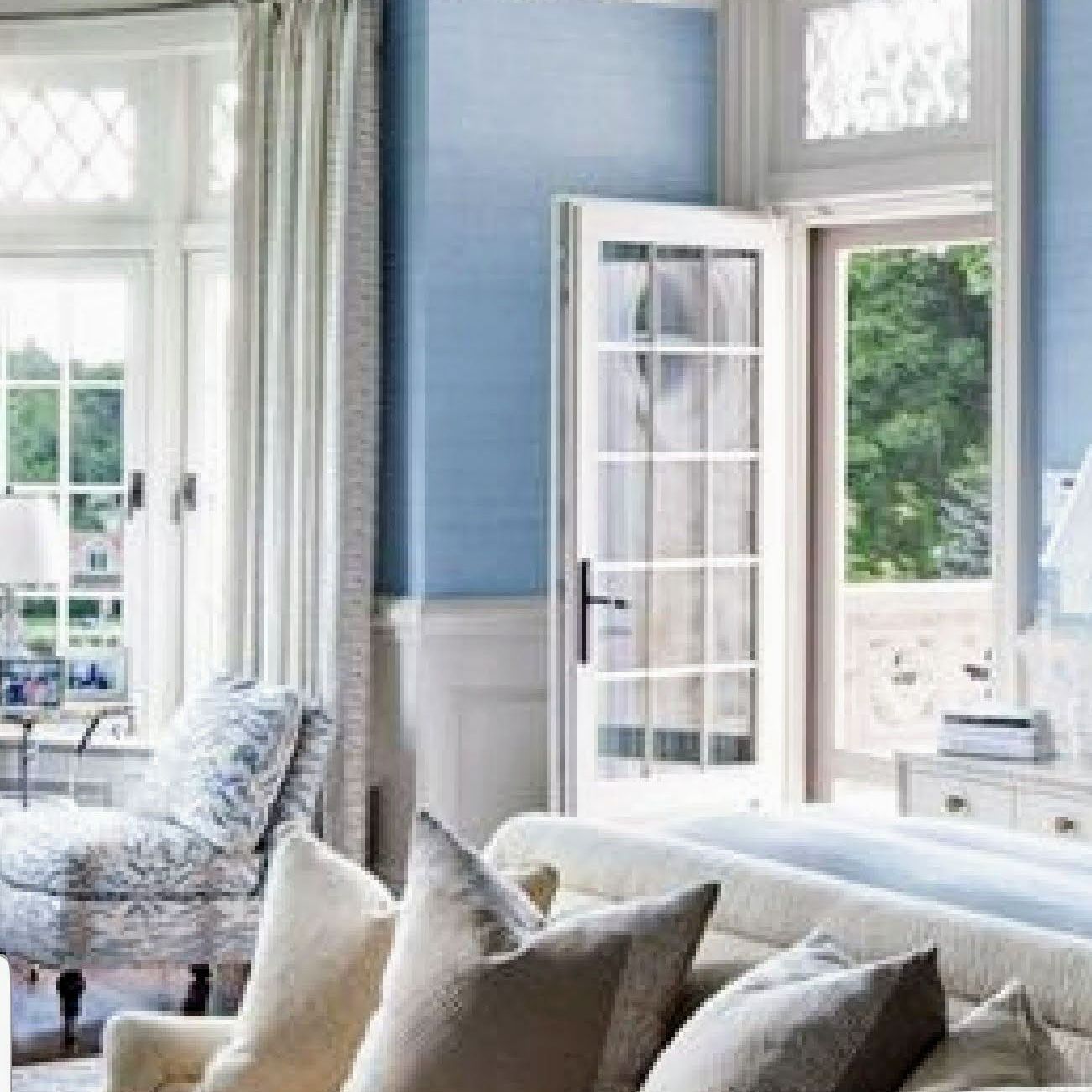 A living room with blue walls and white furniture and a couch. A living room with blue walls and white furniture and a couch.