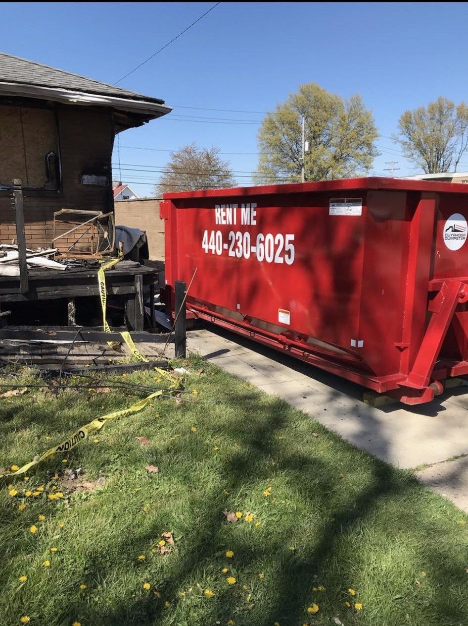a red dumpster is parked in front of a house .