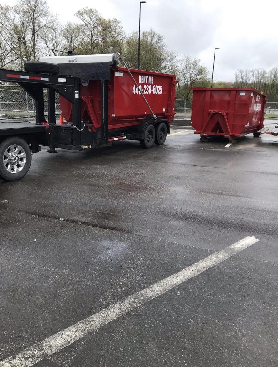 a red dumpster is parked in a parking lot
