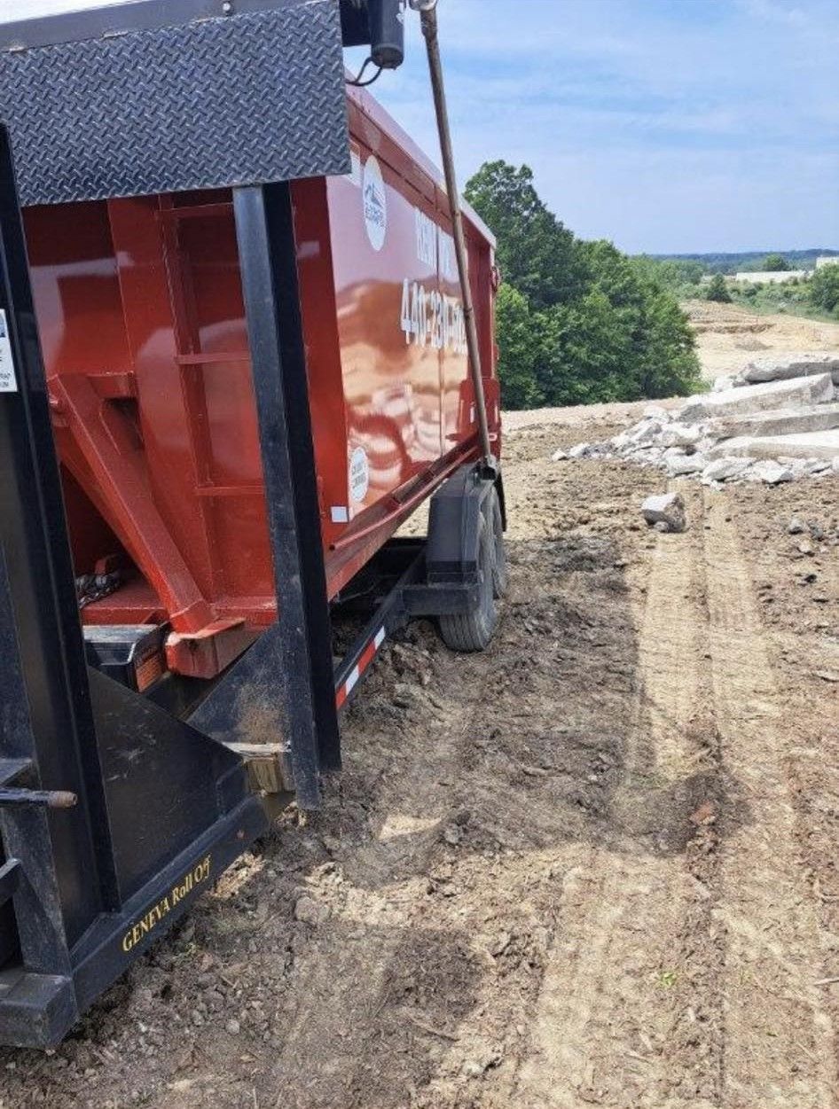 a red dump truck is parked on a dirt road