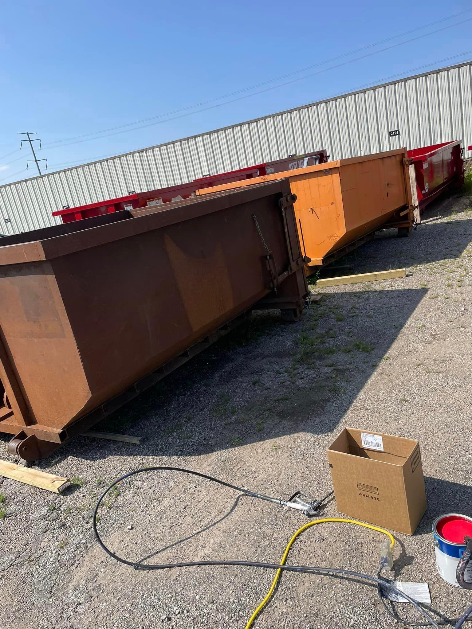 a large rusty dumpster is sitting on the ground next to a box .