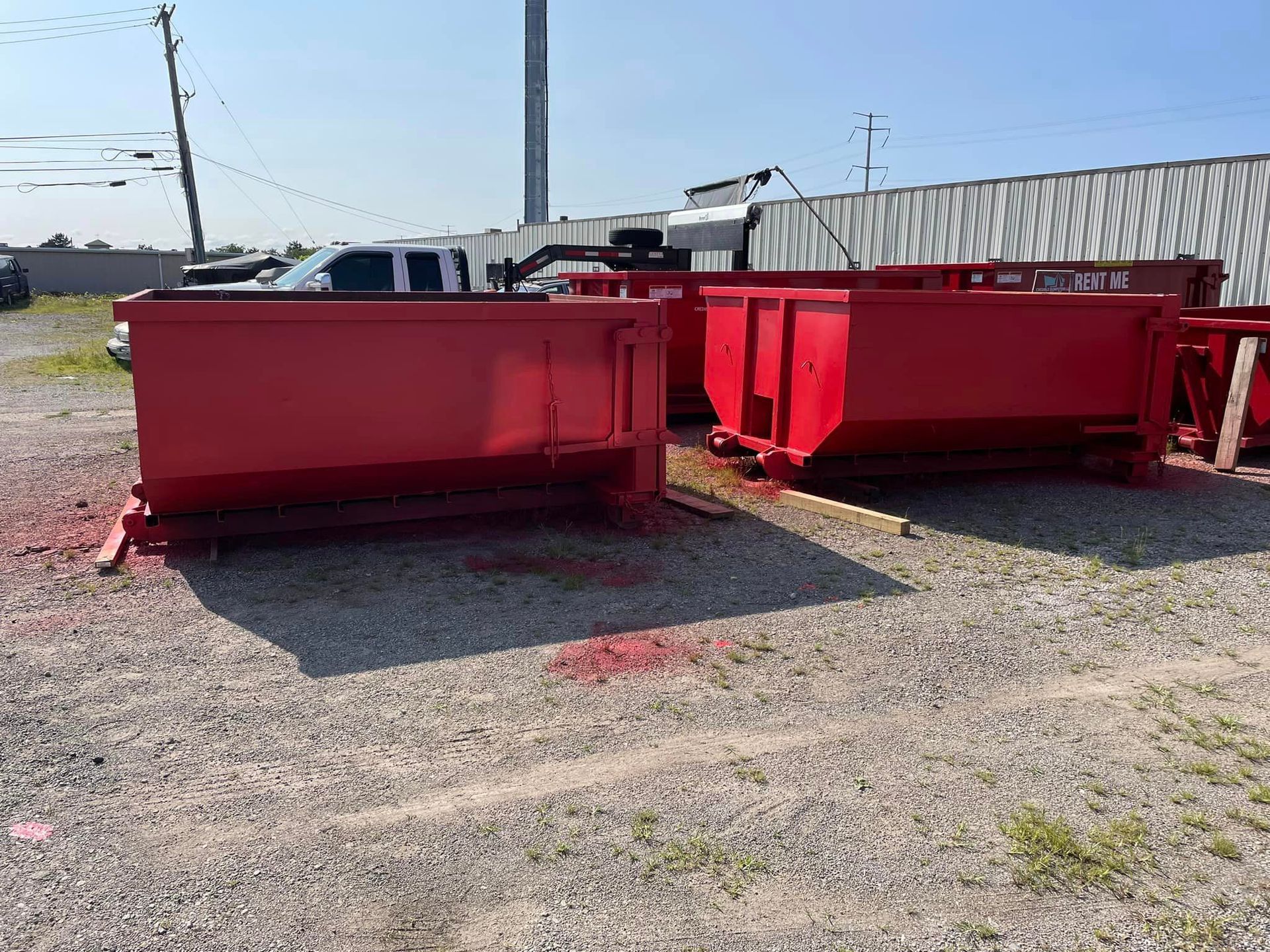 a couple of red dumpsters are sitting in a parking lot .