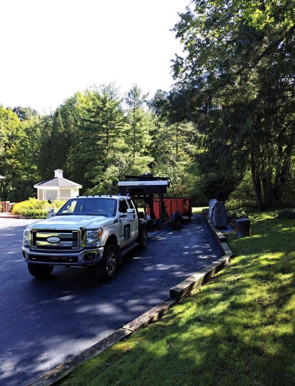 a white truck is parked on the side of the road next to a trailer .