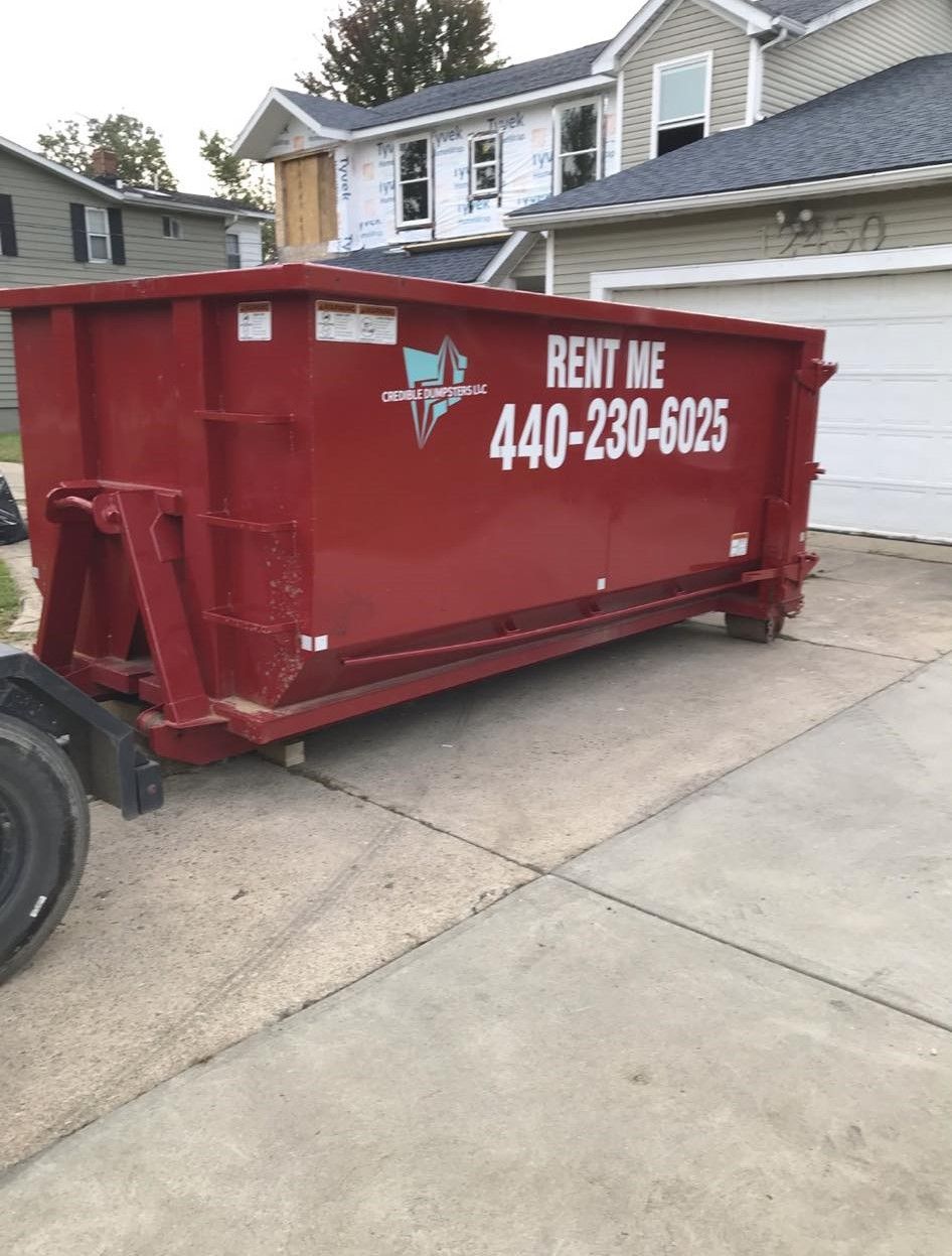 a red dumpster that says rent me on it