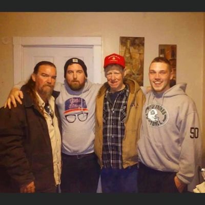 a group of men are posing for a picture and one has the number 50 on his sweatshirt