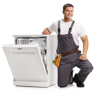 Un hombre está arrodillado junto a un lavavajillas con la puerta abierta.
