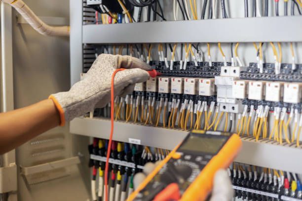 An electrician is using a multimeter to test a circuit board.