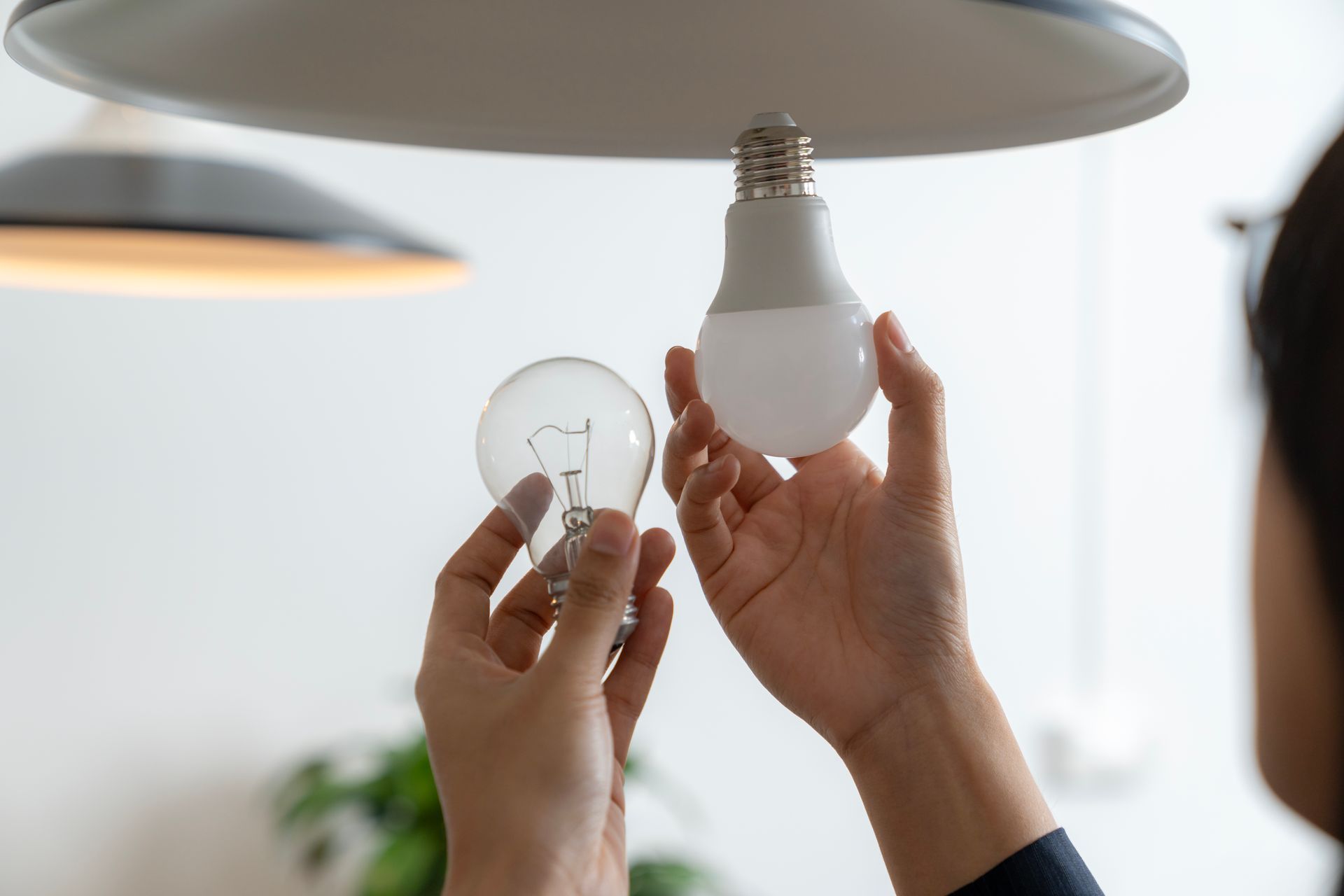 A person is changing a light bulb in a ceiling light.
