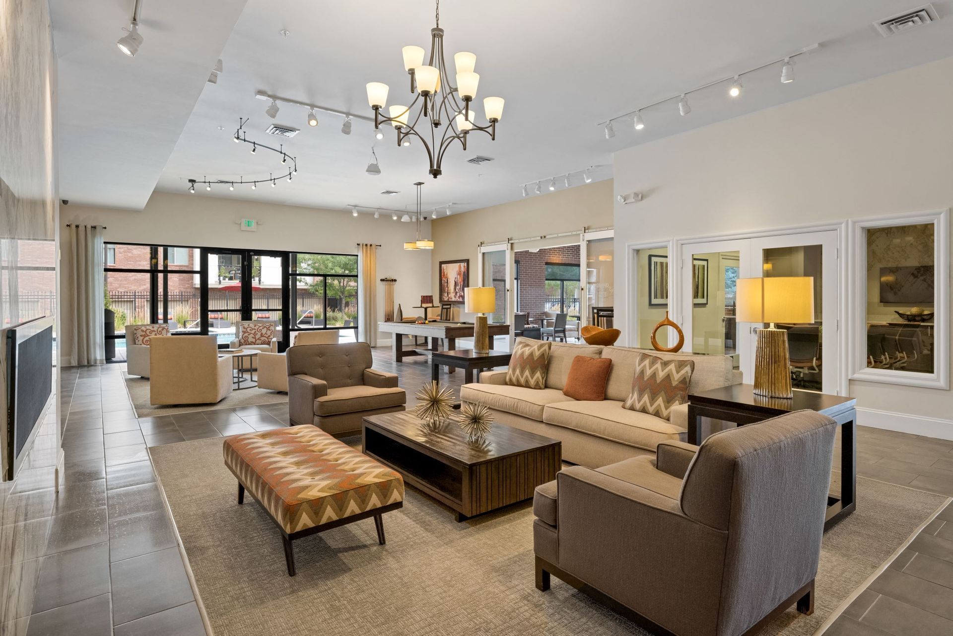Spacious modern apartment community lounge with beige seating and large windows at The Parc at Greenwood Village.