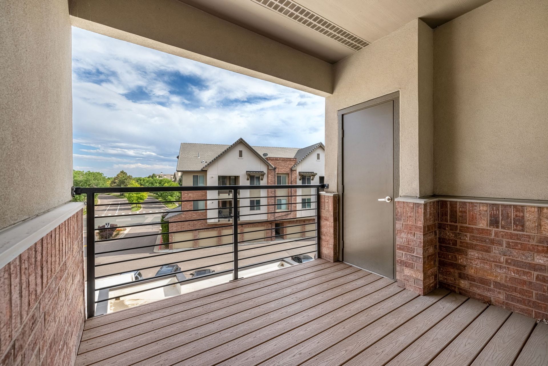 Second-floor balcony with metal railing overlooking neighboring apartment buildings at The Parc at Greenwood Village.