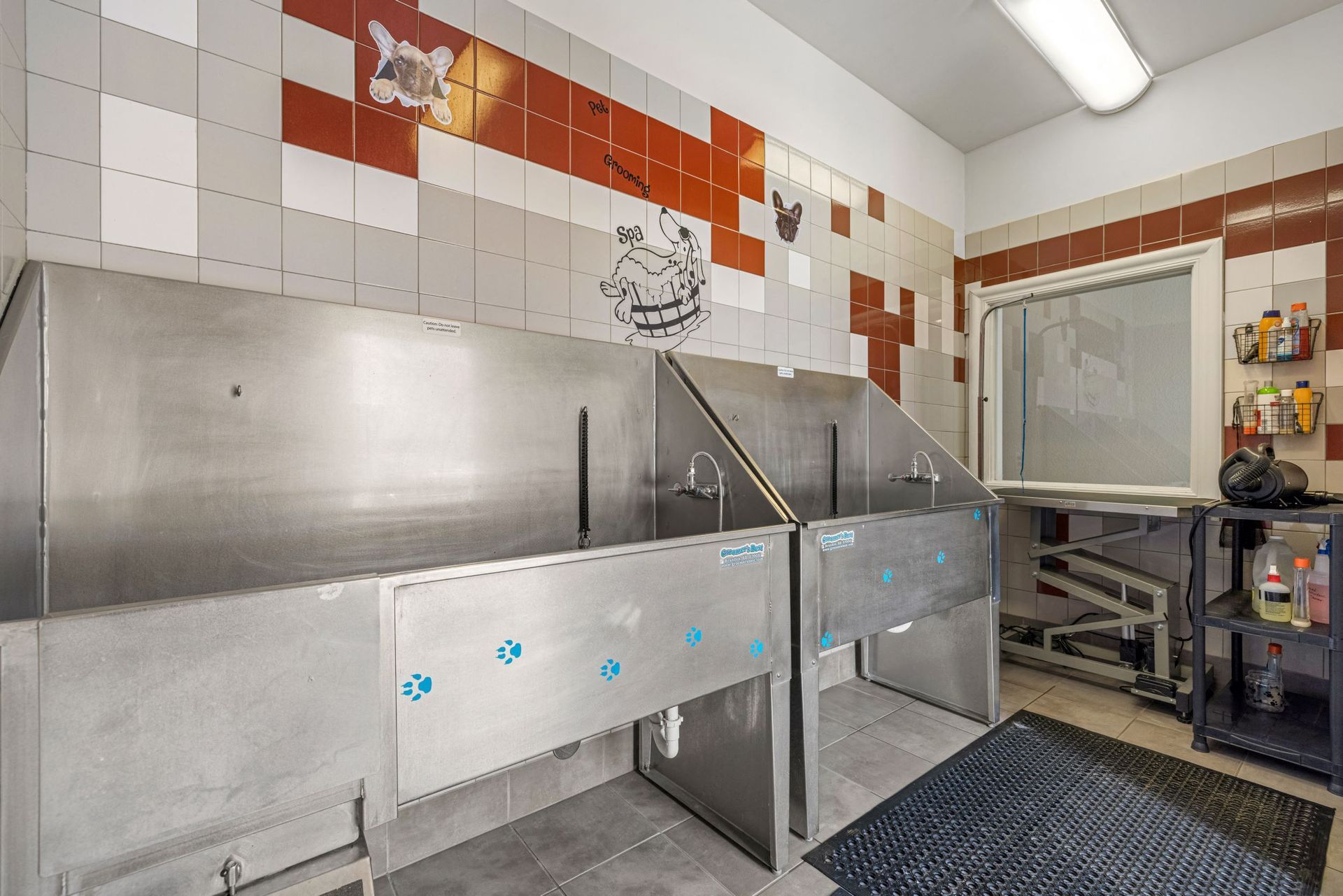 Pet washing station with stainless steel troughs and tiled walls at The Parc at Greenwood Village.
