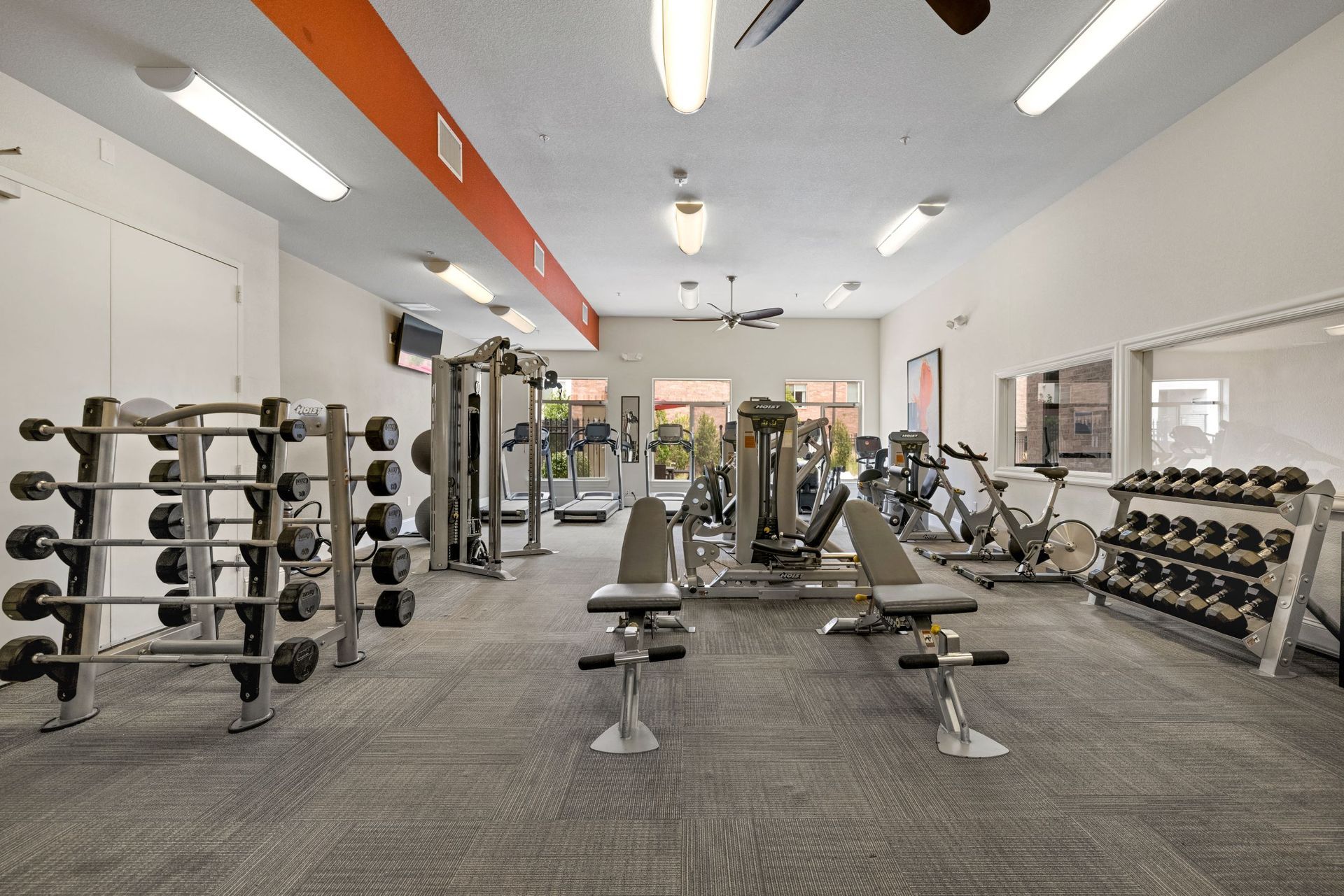Well-lit community gym with treadmills, weight machines, free weights, and benche sat The Parc at Greenwood Village.
