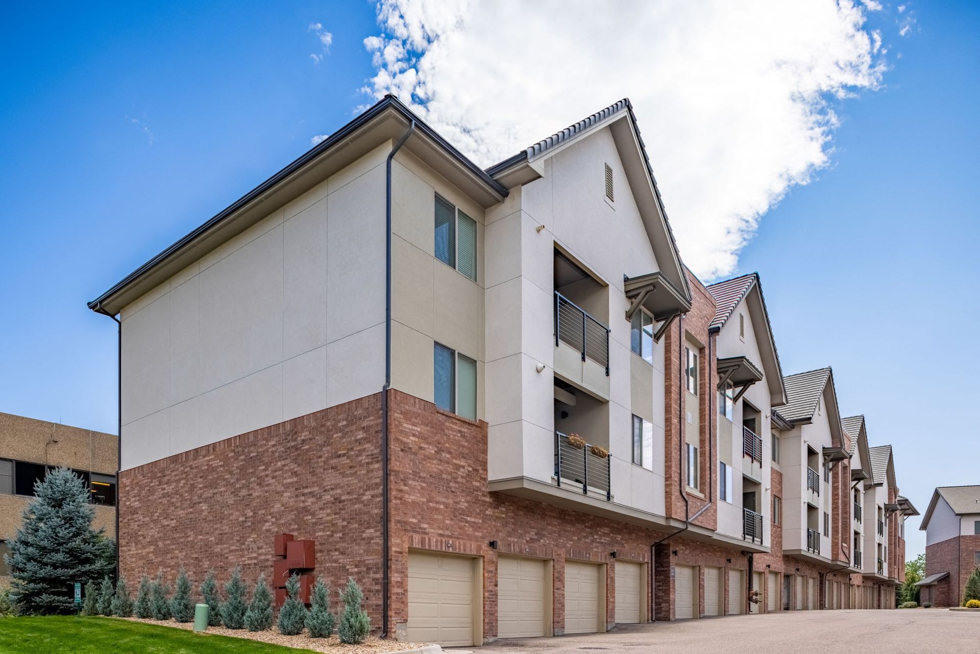 Exterior view of a modern apartment building with brick base and balconiesat The Parc at Greenwood Village.