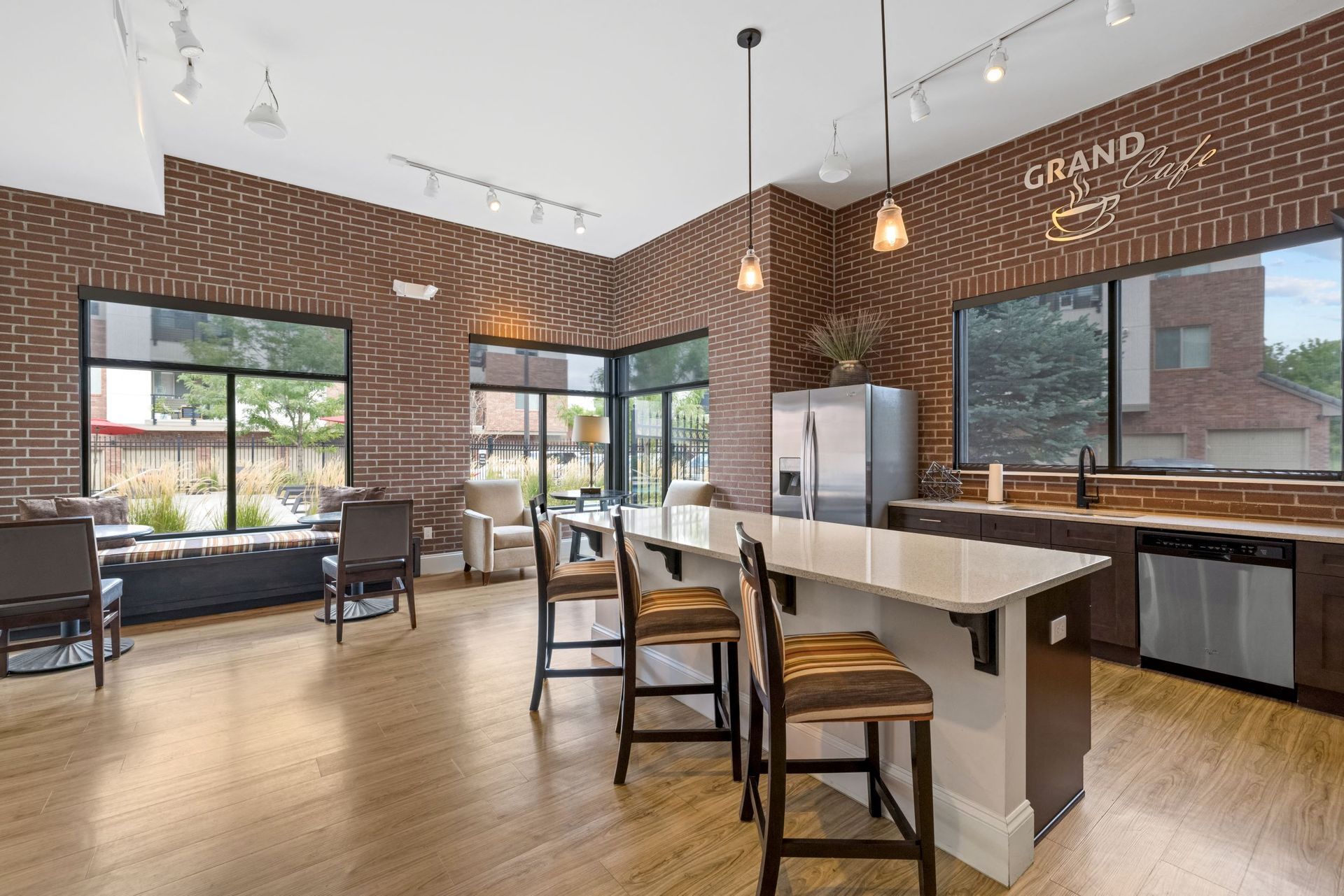 Brick-walled community lounge with a large island kitchen and seating at The Parc at Greenwood Village.