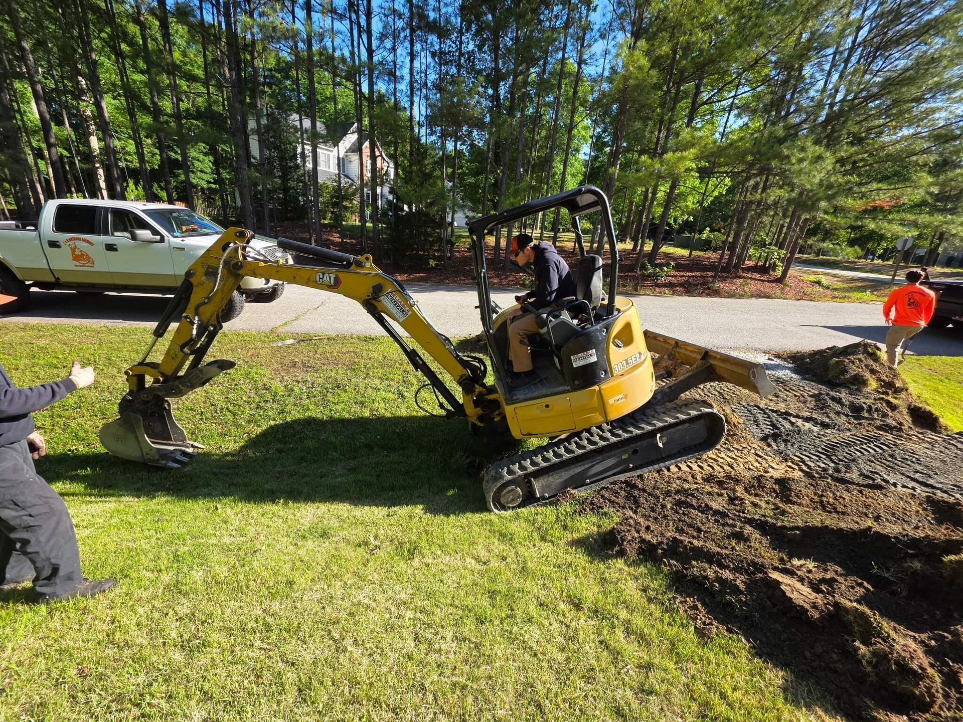 H&H Outdoor Services using an excavator to grade land for a gravel driveway.
