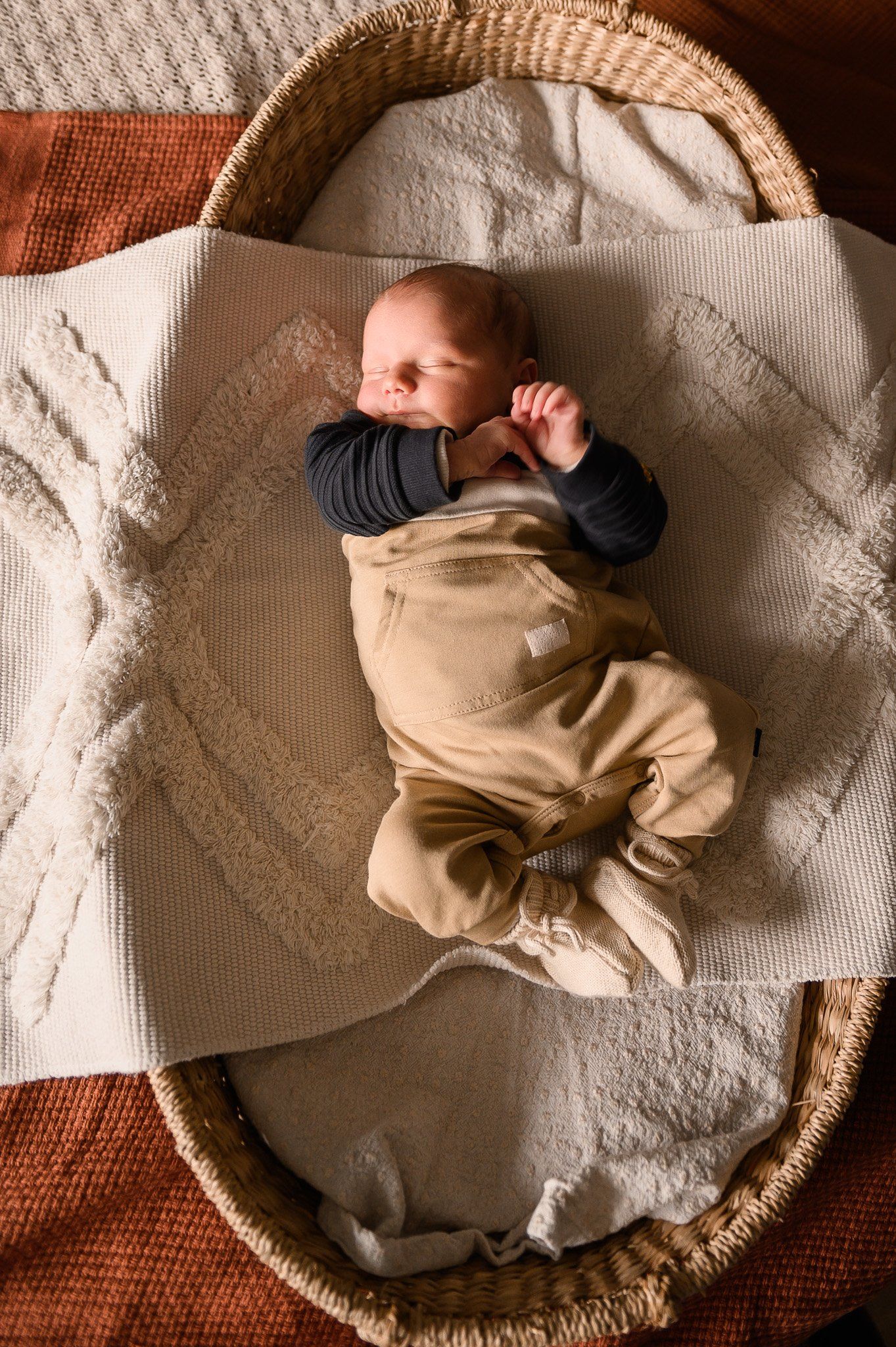 Pasgeboren baby, ingewikkeld in een mandje, slaapt vredig.