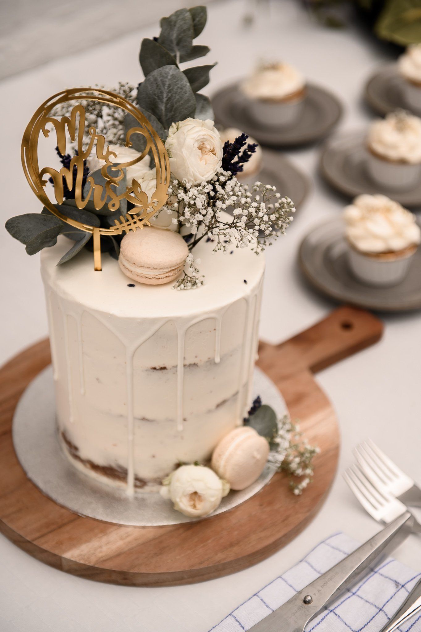 Bruidstaart versierd met bloemen, macarons en een 