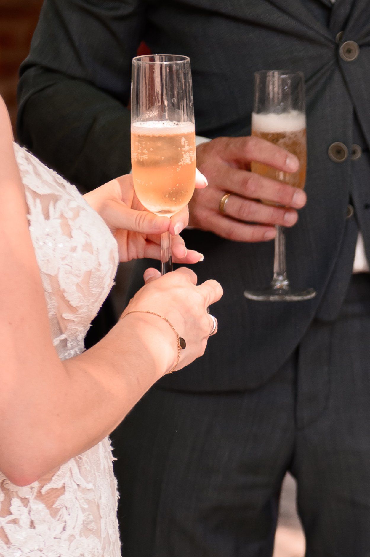 Bruid en bruidegom met champagneglazen in de hand, proostend op hun huwelijk.