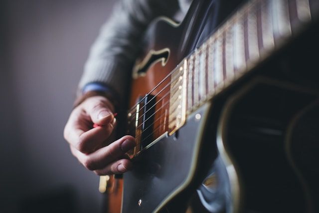 Close-up of a guitarist playing during a memorial service, creating a heartfelt musical tribute to c