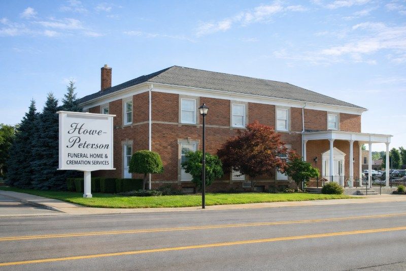 funeral home and cremations Dearborn, MI exterior with Howe-Peterson sign and red brick funeral home building.