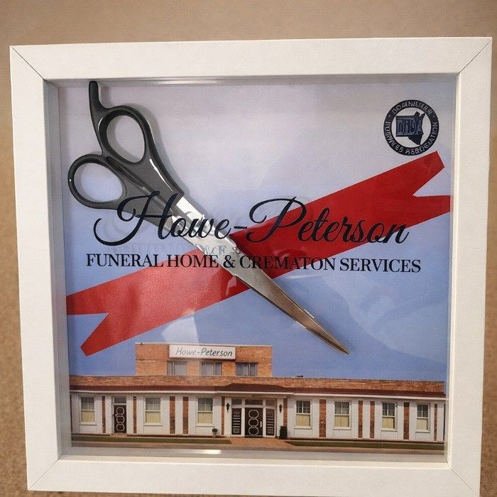 funeral home and cremations Lincoln Park, MI ribbon-cutting display with scissors and Howe-Peterson building photo.