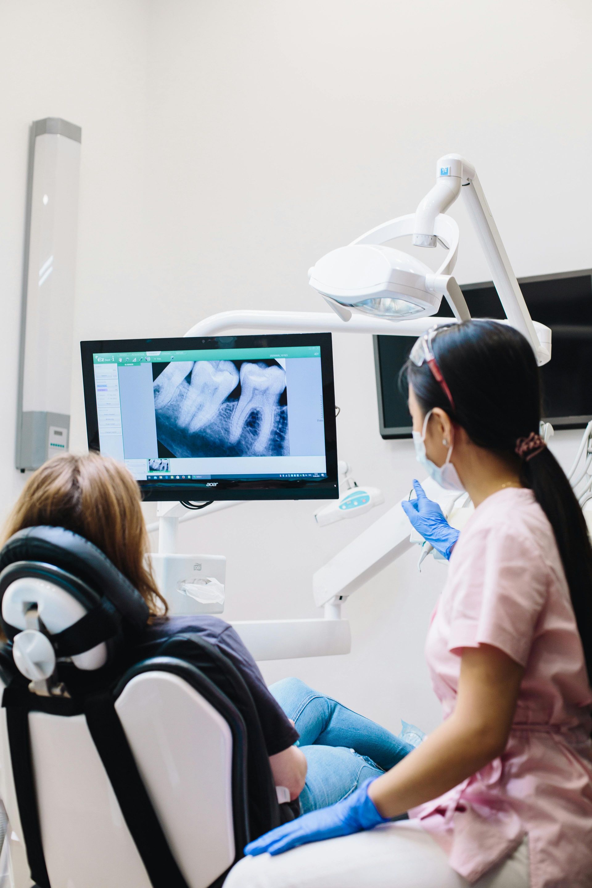 Dentist showing patient a dental X-ray on a monitor in a dental office.