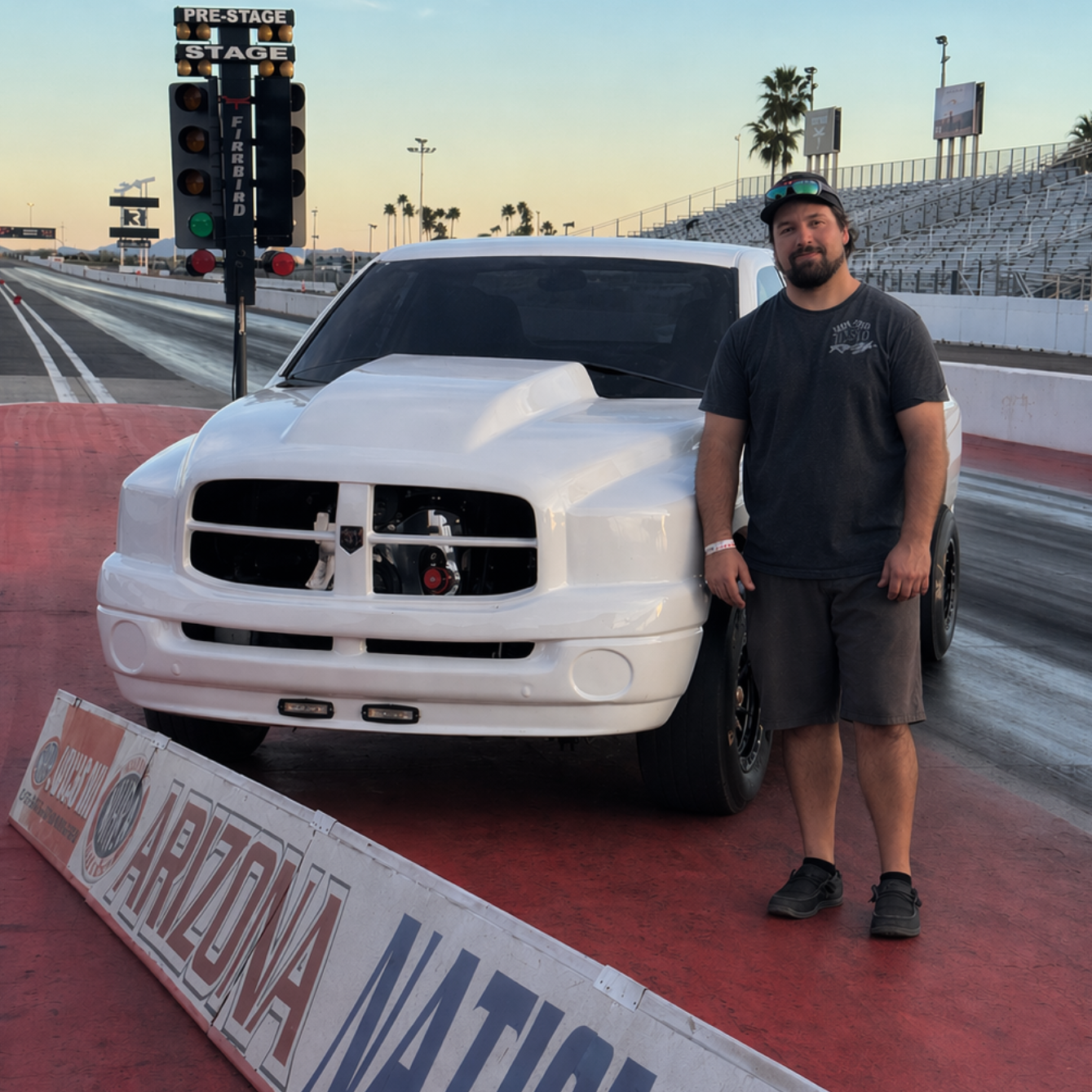 White diesel-powered race truck named Opie and owner Phillip Franklin at a drag strip with a man standing beside it
