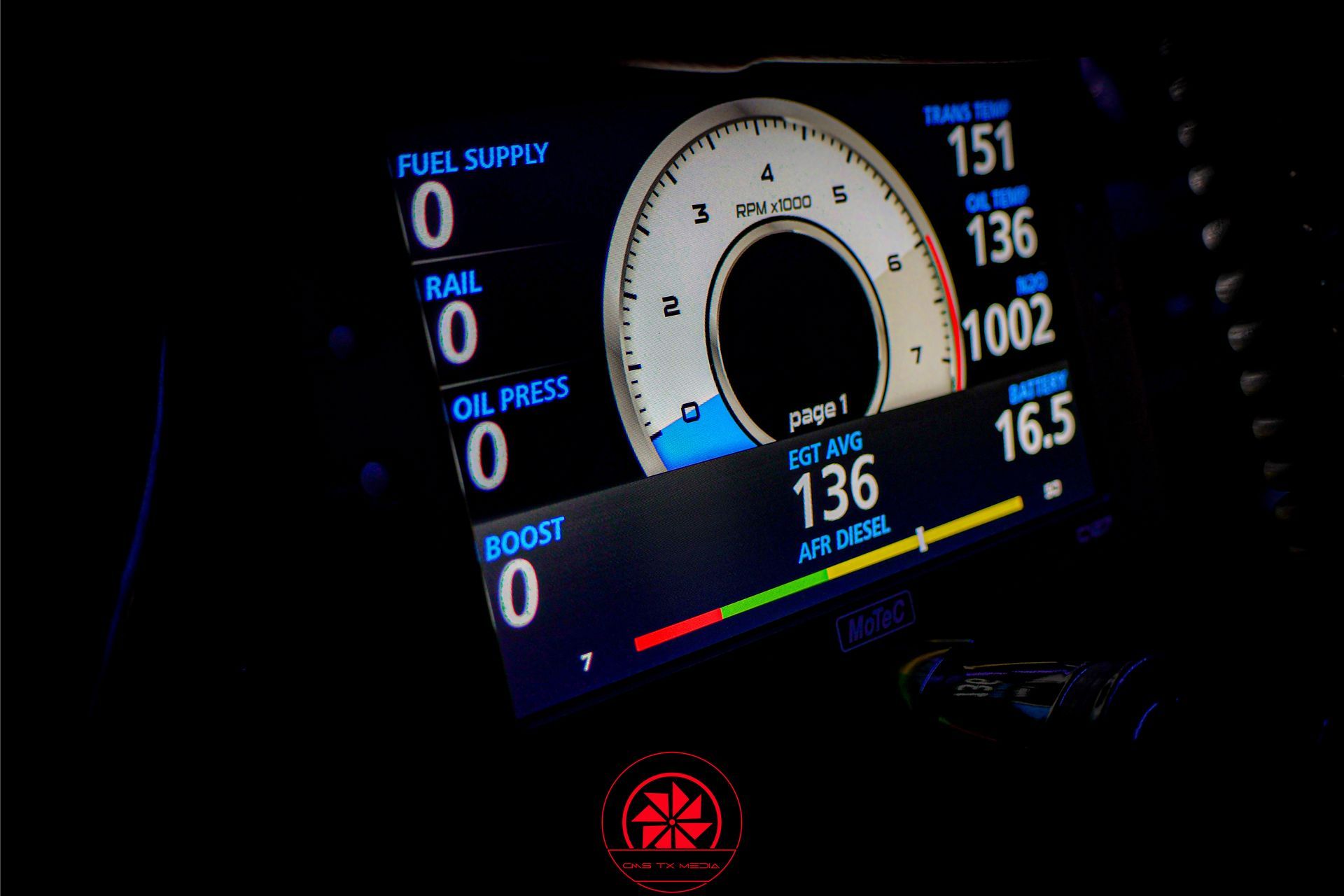 Digital dashboard display in a dark car interior, showing a large white gauge and blue performance stats.