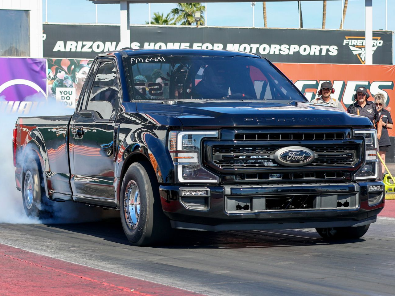 Black diesel-powered Ford pickup truck named Blackbird doing a burnout on a drag strip