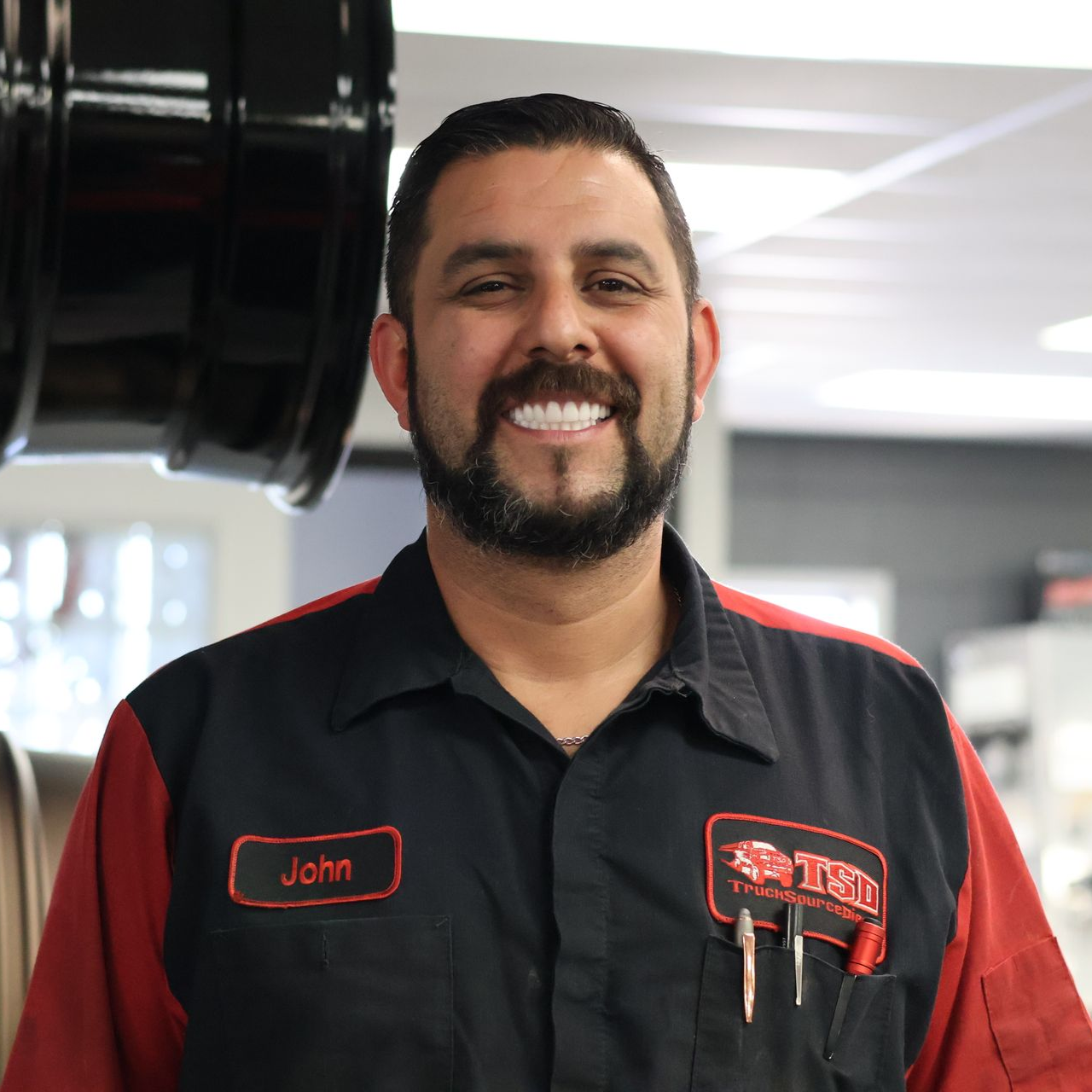 Josh Munoz in a black and red uniform at the TSD shop