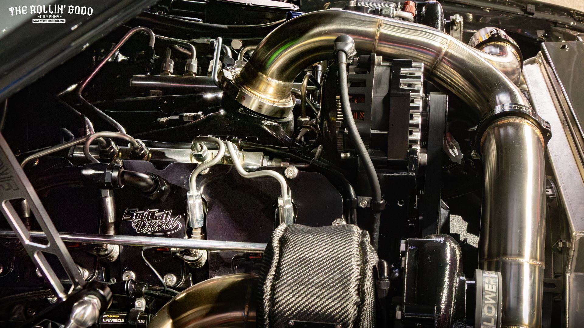 Close-up of a car engine bay with polished metal pipes and components under the hood