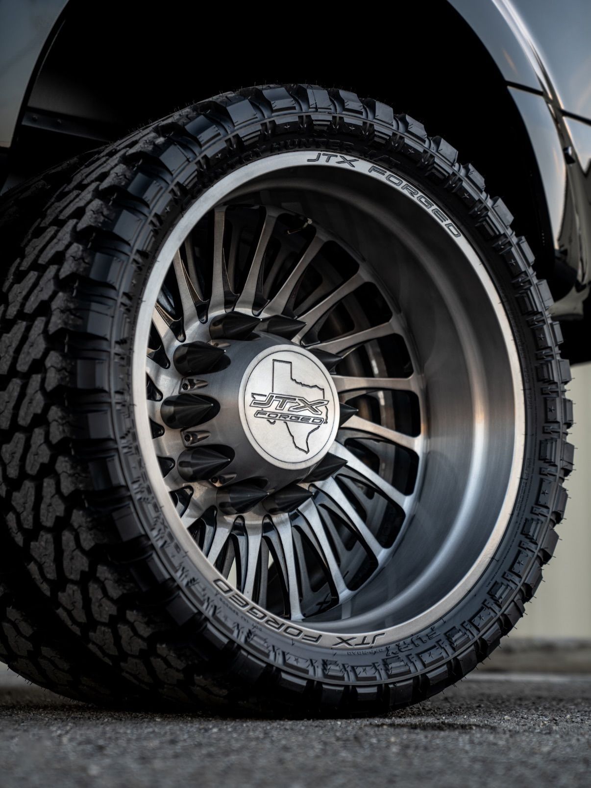 Close-up of a black off-road tire and shiny custom wheel on a vehicle