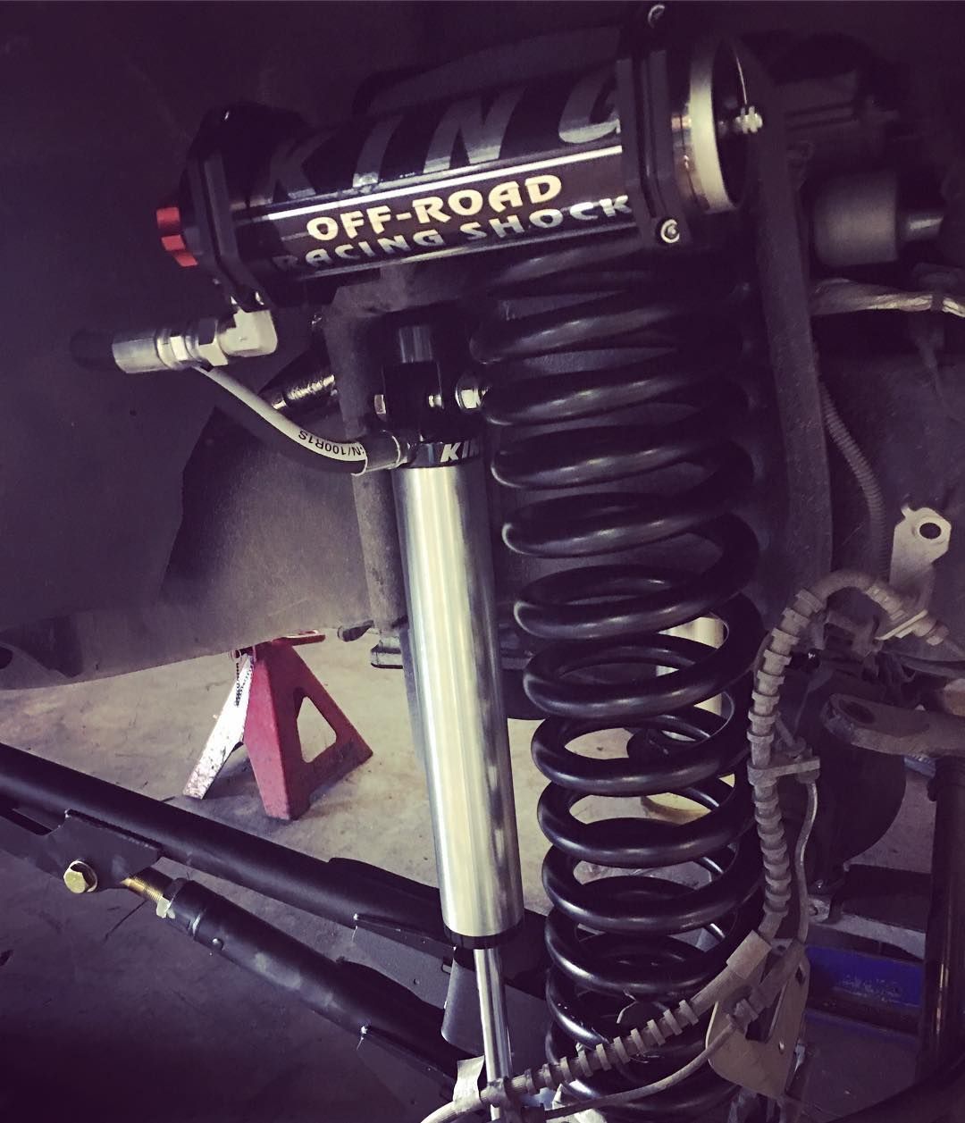 Close-up of an off-road vehicle suspension with coil spring and shock absorber installed.