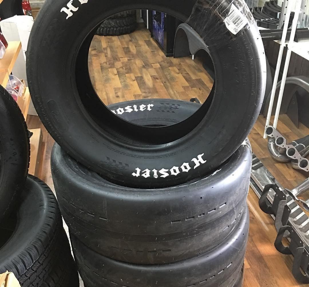 Stack of black Hoosier racing tires in a store display