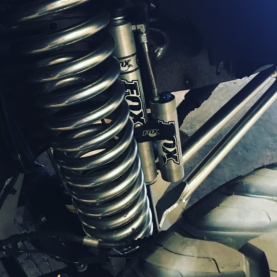 Close-up of a car suspension coil spring and shock absorber with a metal bracket.