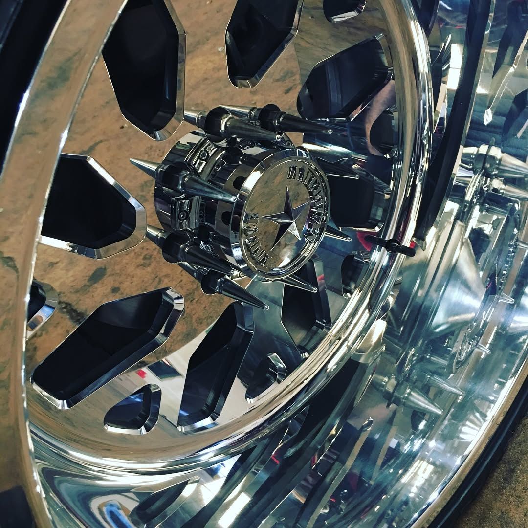 Close-up of a shiny chrome car wheel rim with black spokes and reflective details.