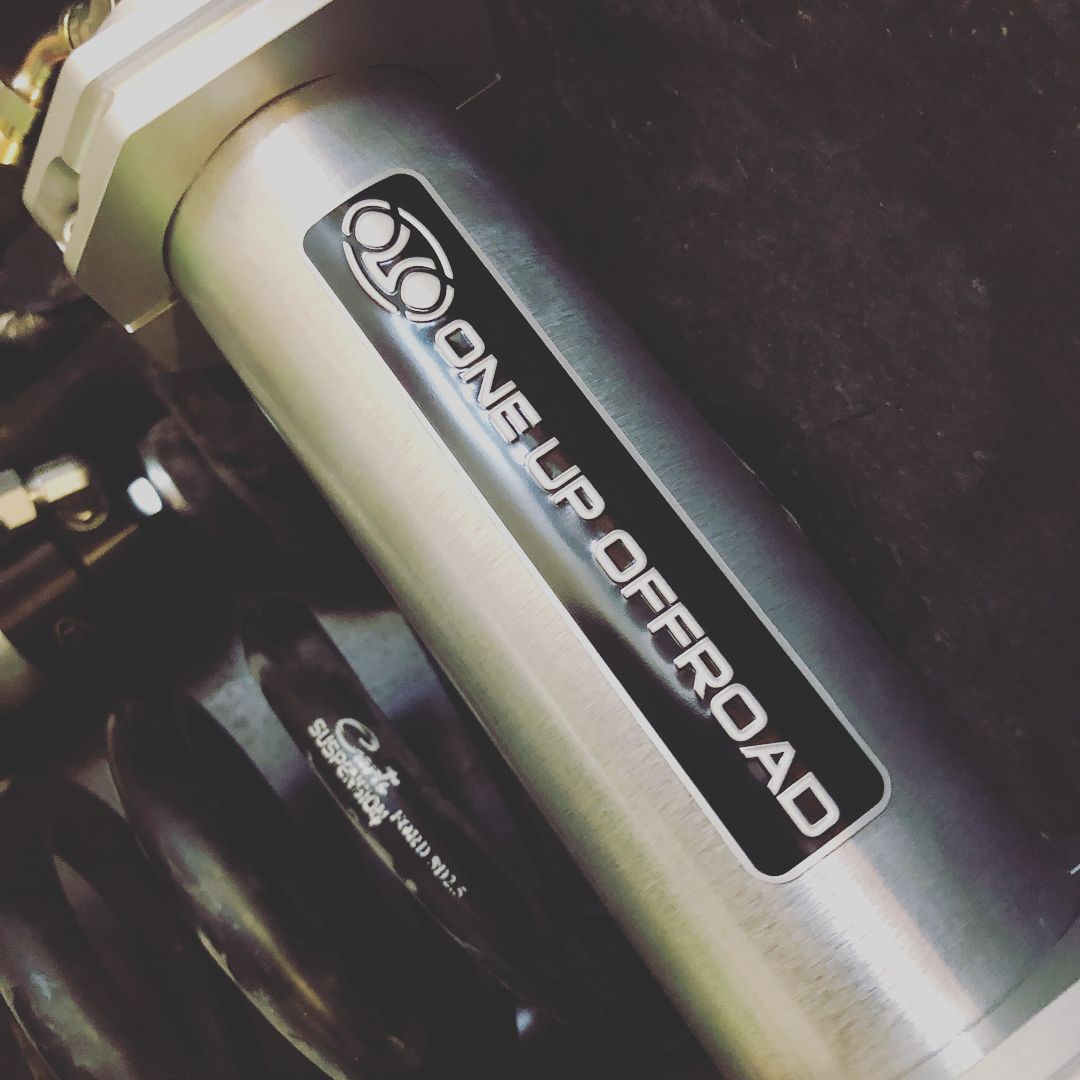 Close-up of a silver ON-L-ROAD motorcycle suspension component with black branding label.