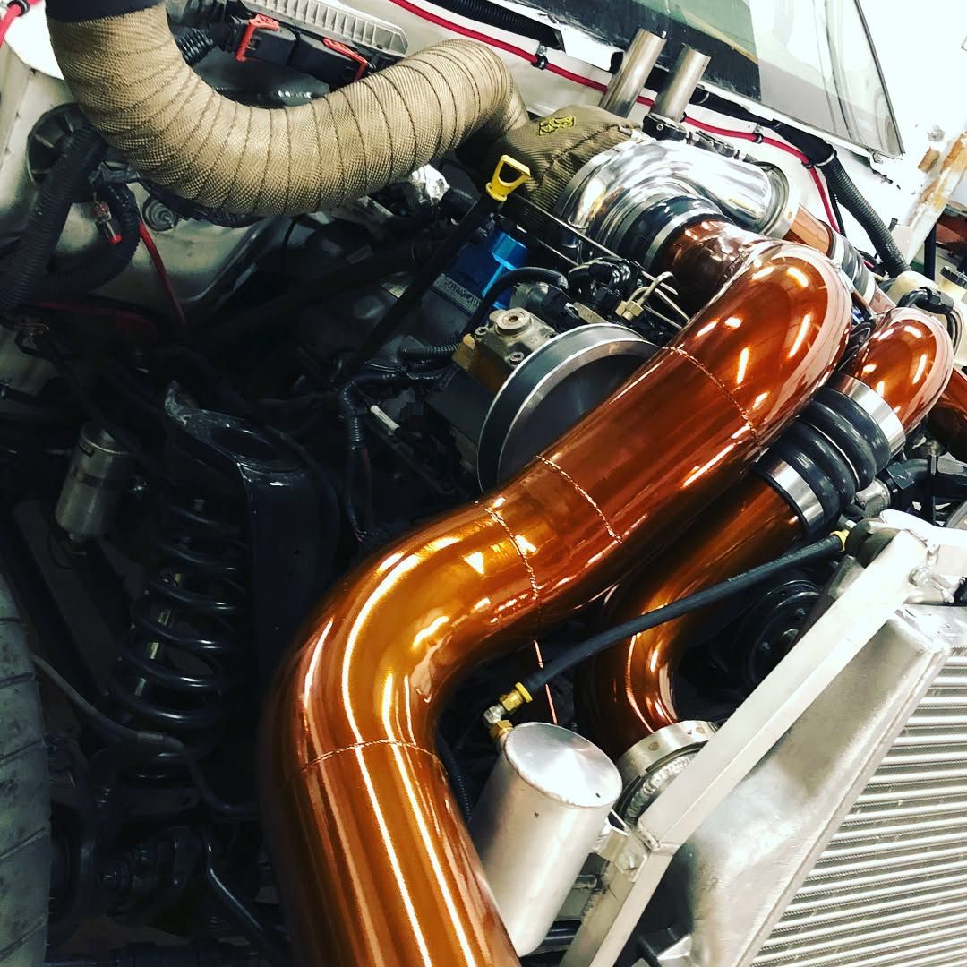 Engine bay with glossy copper intake pipes and wrapped turbo plumbing
