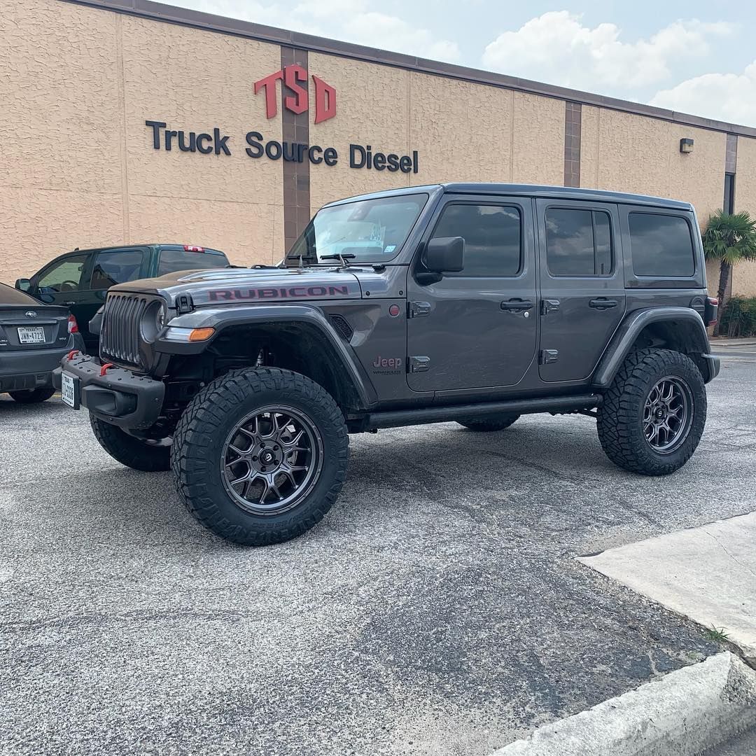 Black lifted Jeep Wrangler parked on gravel outside Truck Source Diesel building.