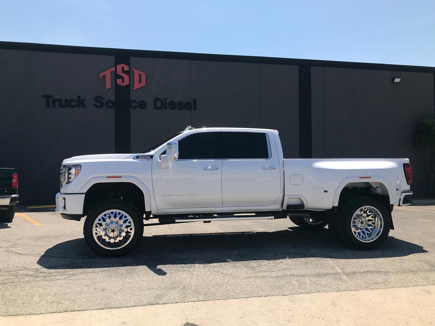 White lifted pickup truck parked outside Truck Service Diesel shop