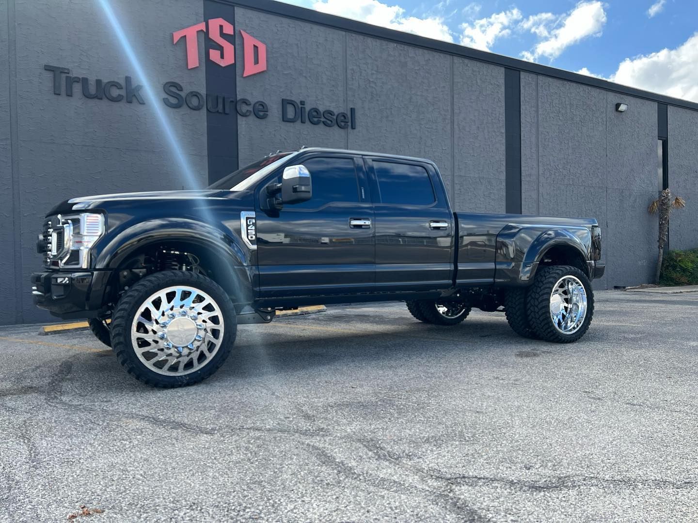 Black lifted pickup truck parked outside Truck Source Diesel building