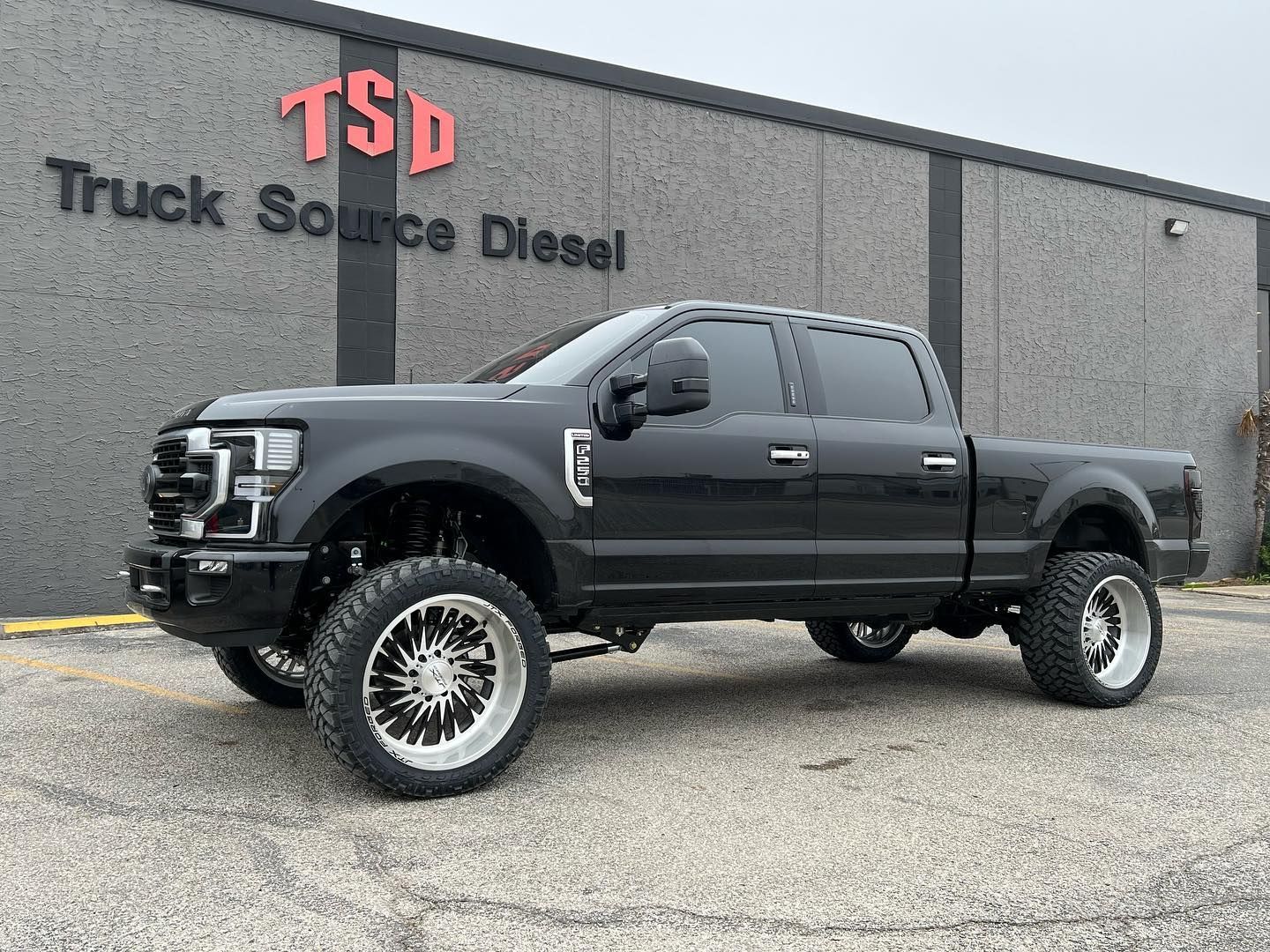 Black lifted pickup truck parked outside Truck Source Diesel building
