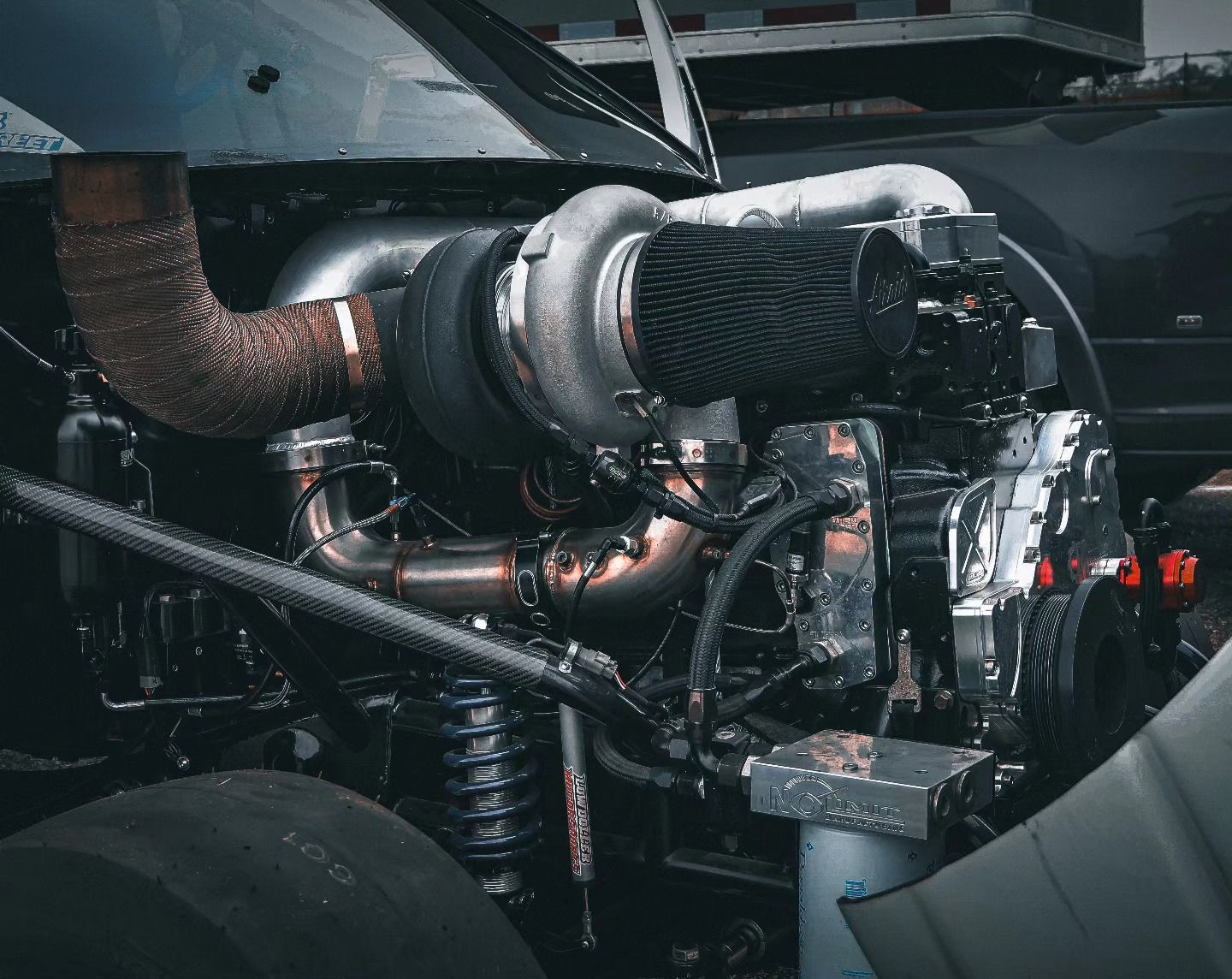 Close-up of a car engine bay with a large turbocharger and exposed metal piping