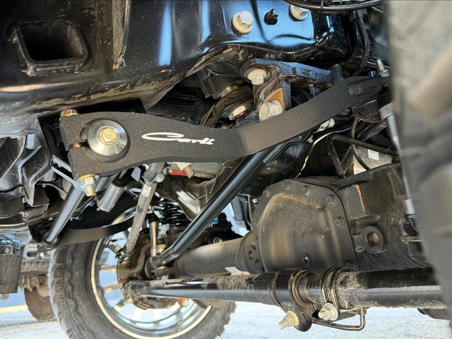 Undercarriage of a vehicle with suspension, axle, and exhaust components visible