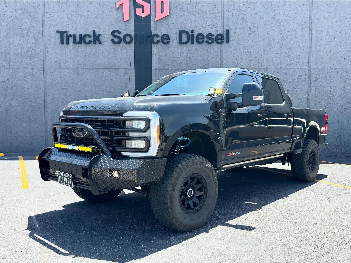 Black lifted pickup truck parked outside Truck Source Diesel dealership