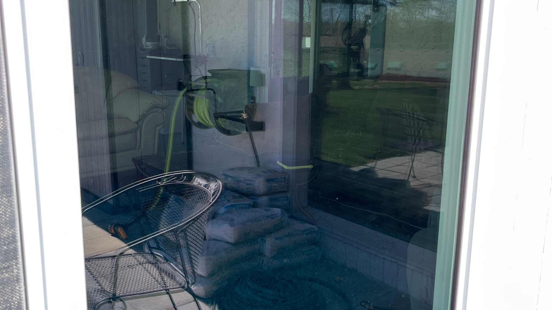 A chair is sitting in front of a window with a hose attached to it.
