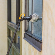 A brush is being used to clean a window on a building.