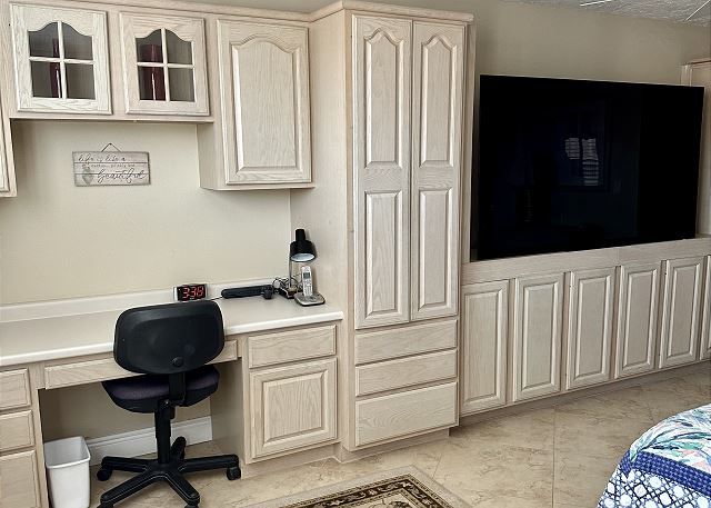 There is a desk with a chair in the middle of the room.