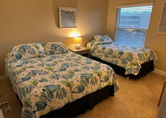 A bedroom with two beds and a window.