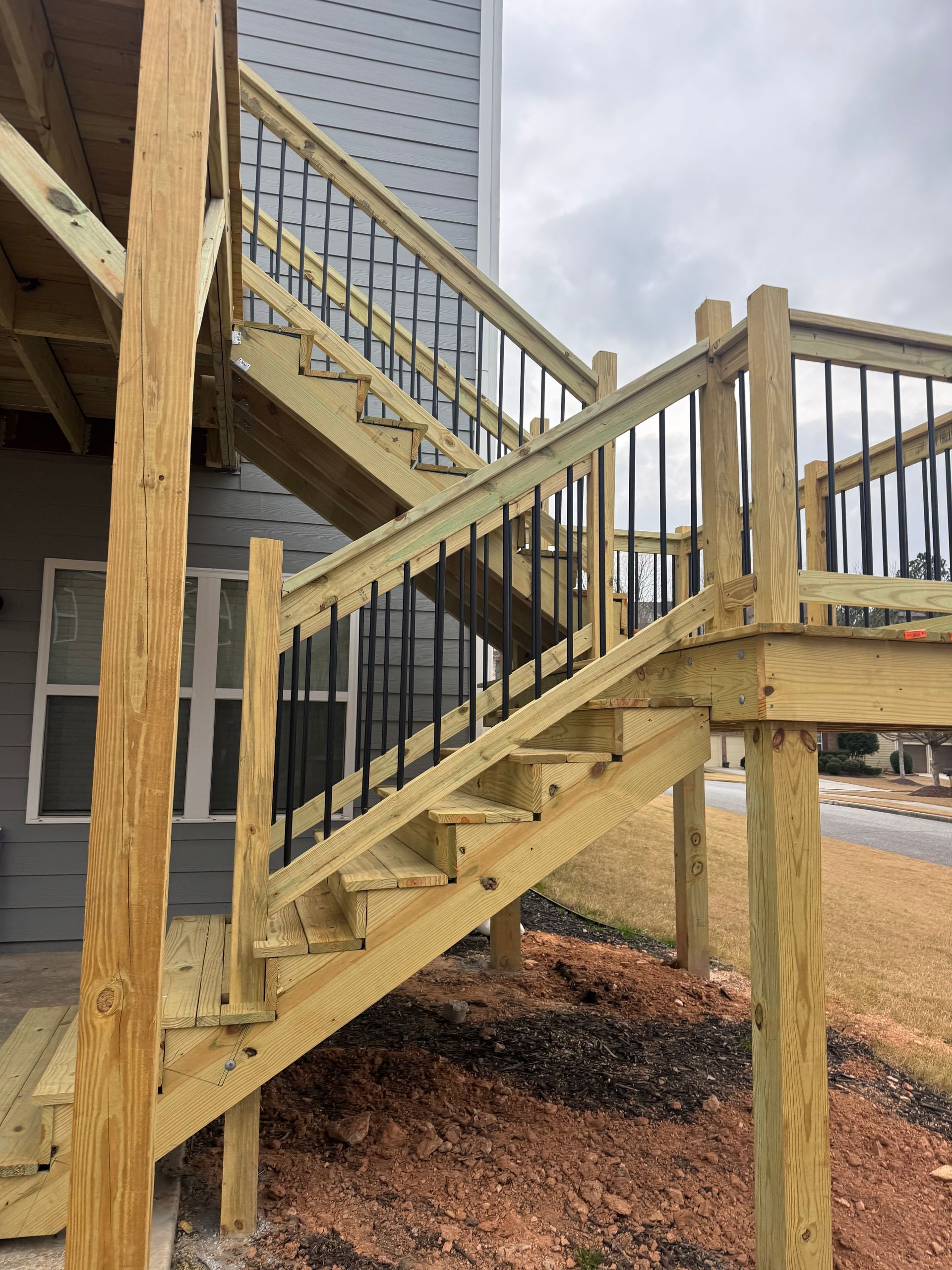 Wooden outdoor staircase with railings attached to a house on raised supports